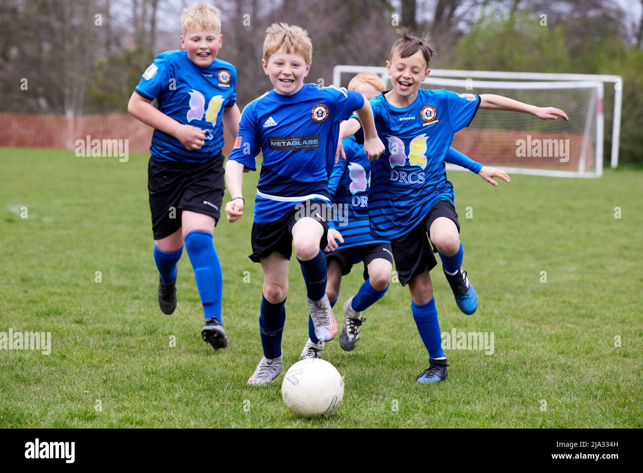 Tupton Ivanhoe FC, jeunes enfants jouant au football sur gazon Banque D'Images