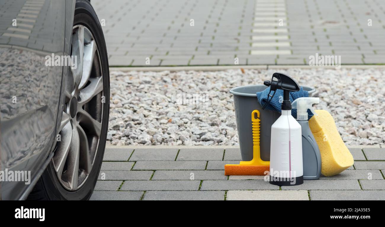 produits de nettoyage de voiture et une voiture sale côte à côte Banque D'Images