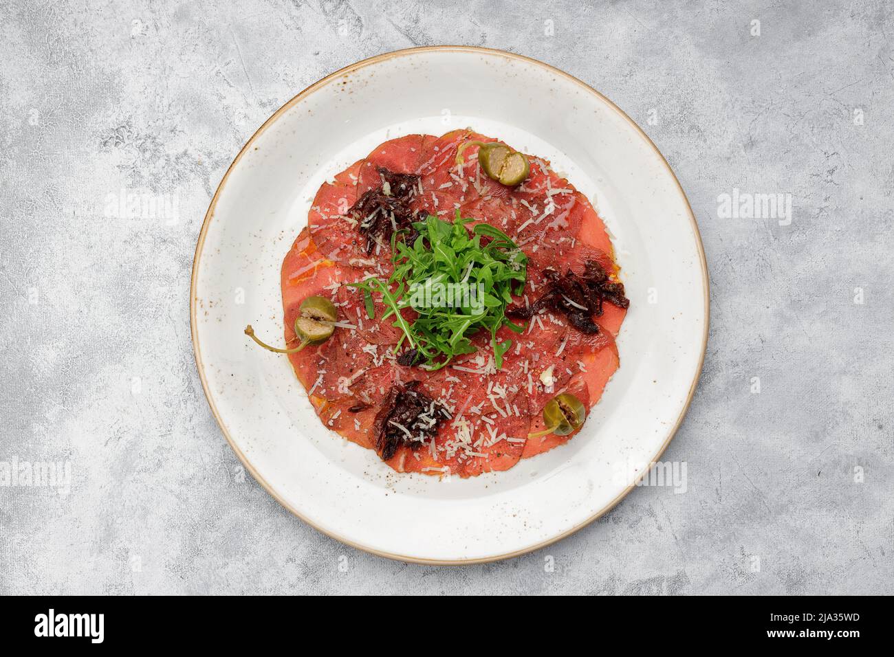 Carpaccio de filet de veau, avec arugula et câpres, sur une assiette, sur  fond clair Photo Stock - Alamy