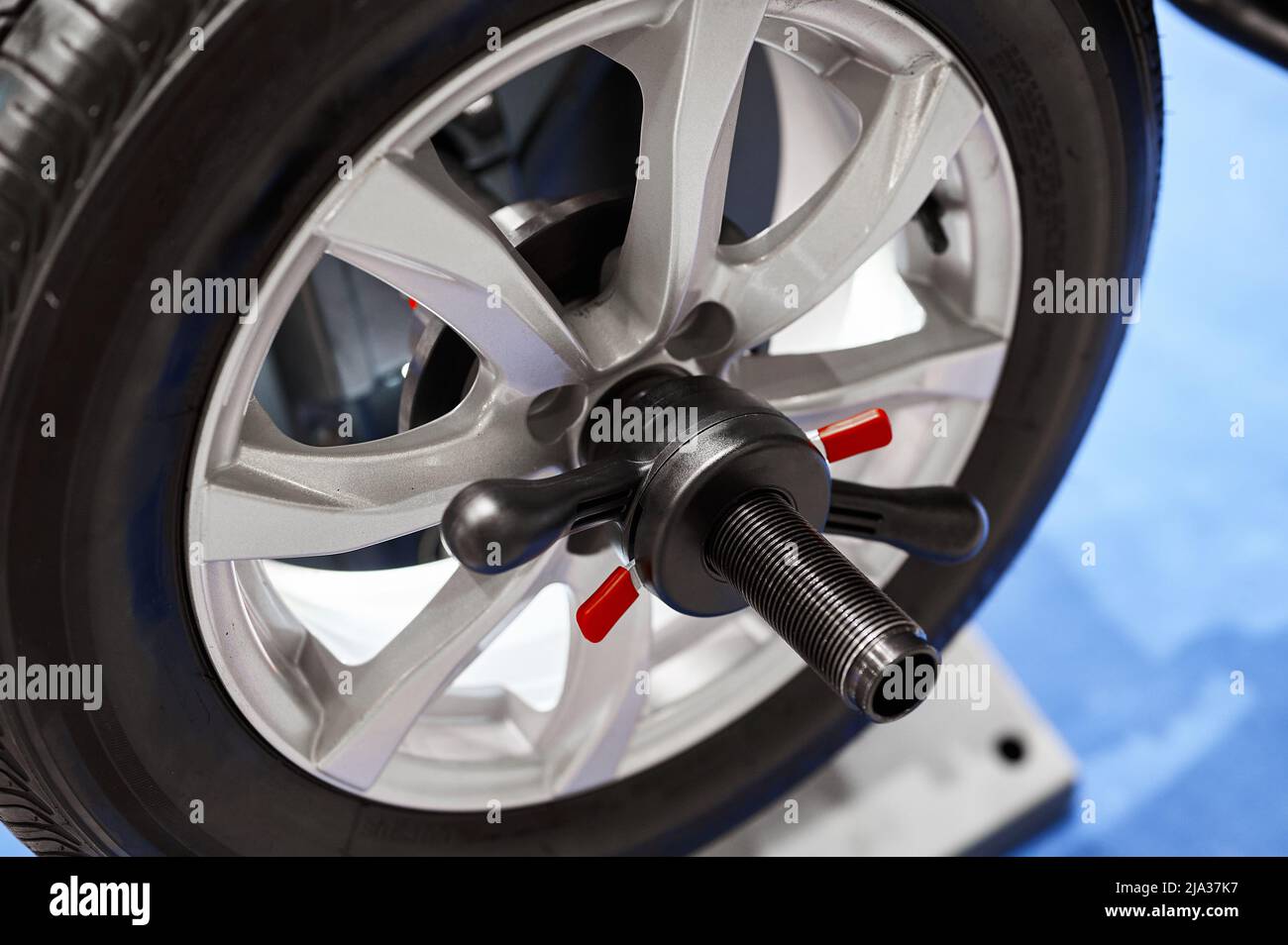 Roue de voiture avec pneu sur support d'équilibrage à l'atelier de réparation Banque D'Images Roue de voiture avec pneu sur support d'équilibrage à l'atelier de réparation Banque D'Images