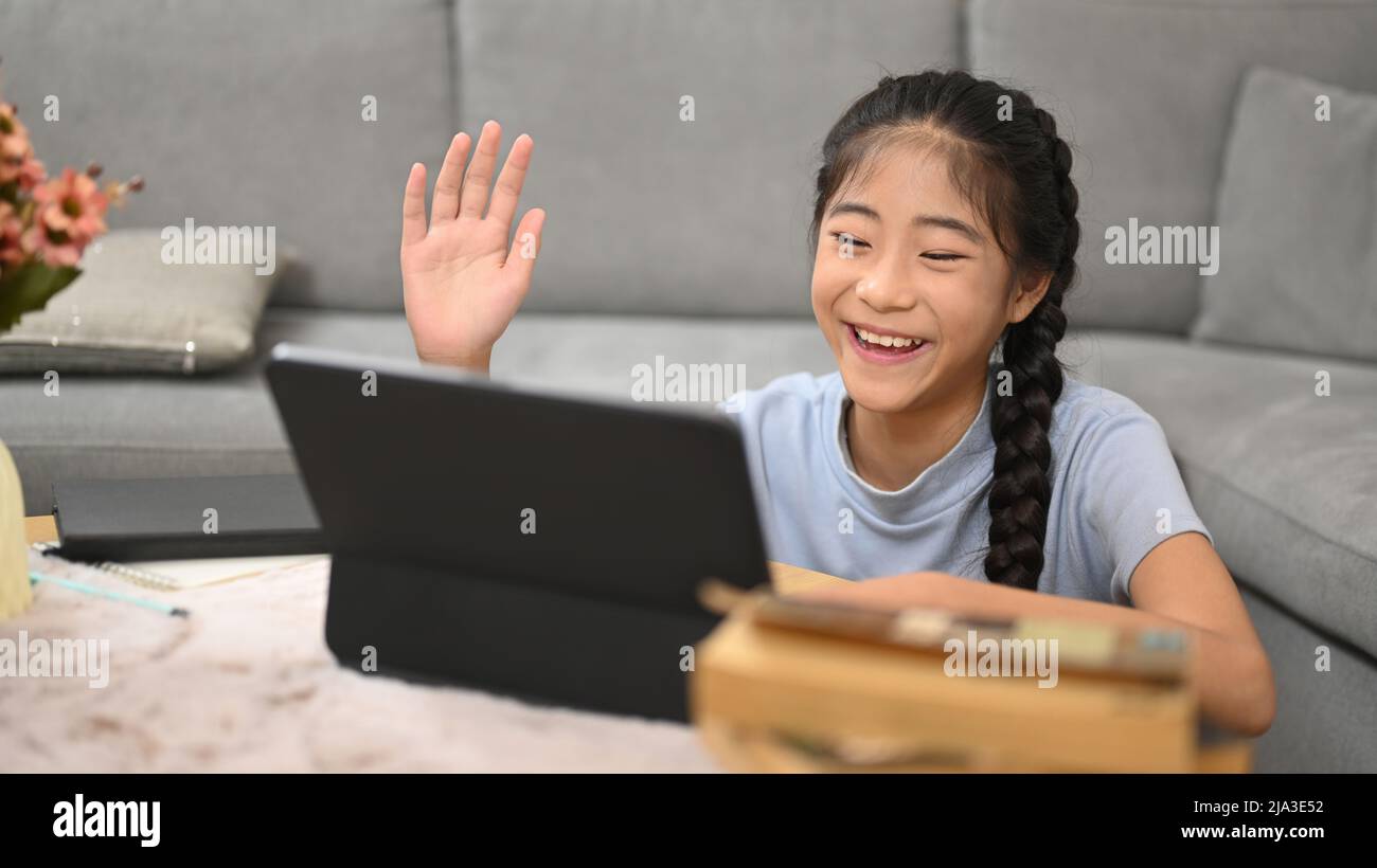 Bonne fille asiatique regardant l'apprentissage en ligne dans la salle de classe virtuelle sur ordinateur portable. Concept d'éducation à l'apprentissage en ligne Banque D'Images