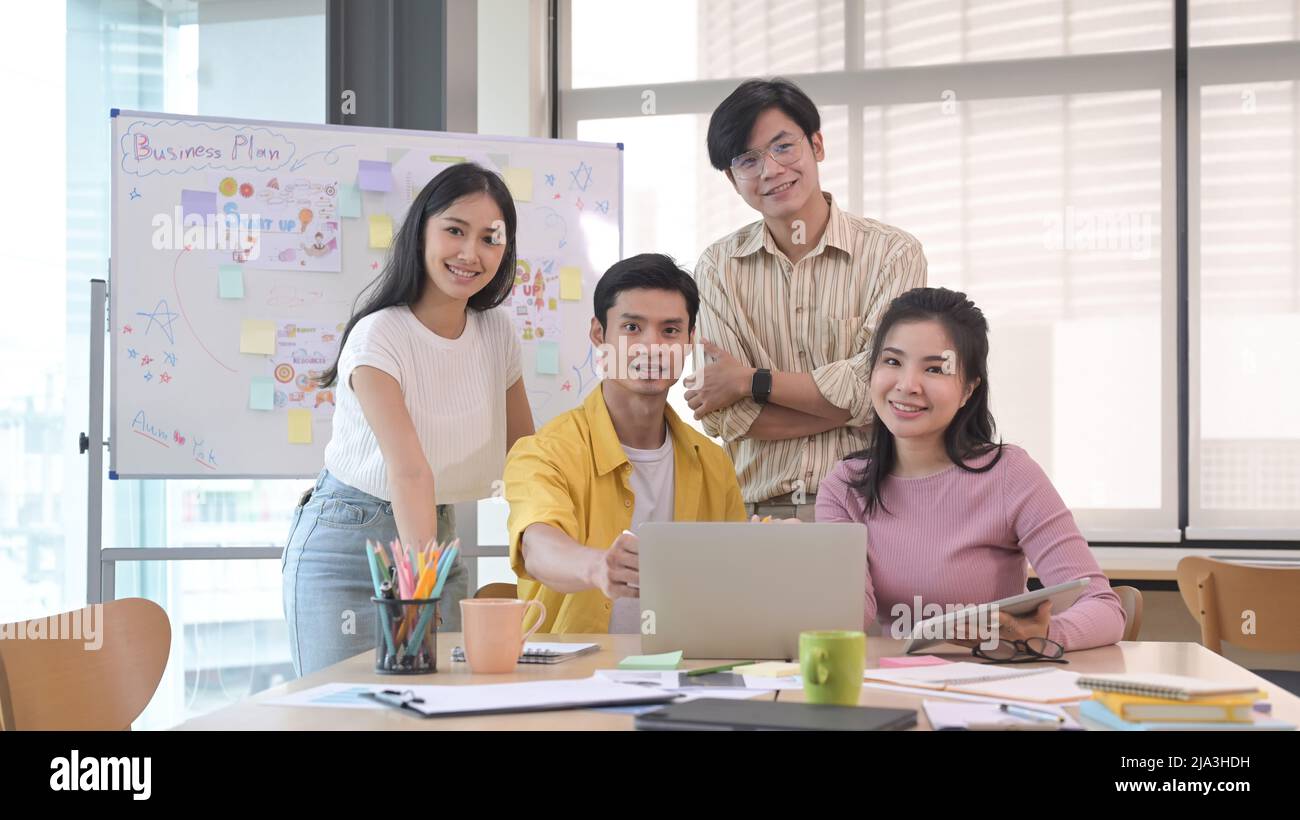 Une équipe d'affaires réussie se réunit dans la salle de réunion et se pose souriante pour le concept Camera.Teamwork. Banque D'Images