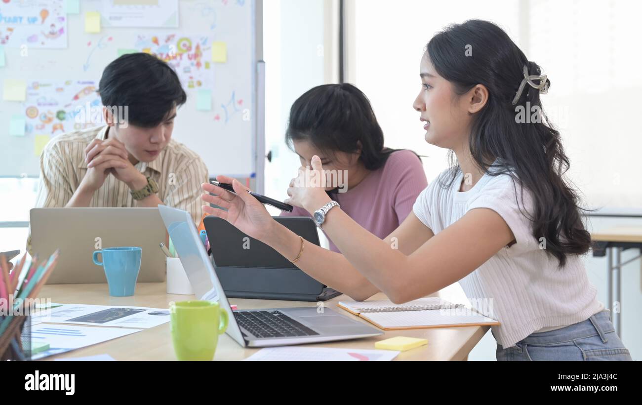 Les jeunes hommes d'affaires remue-méninges et discutent ensemble d'idées pour un nouveau projet de démarrage au bureau moderne. Banque D'Images