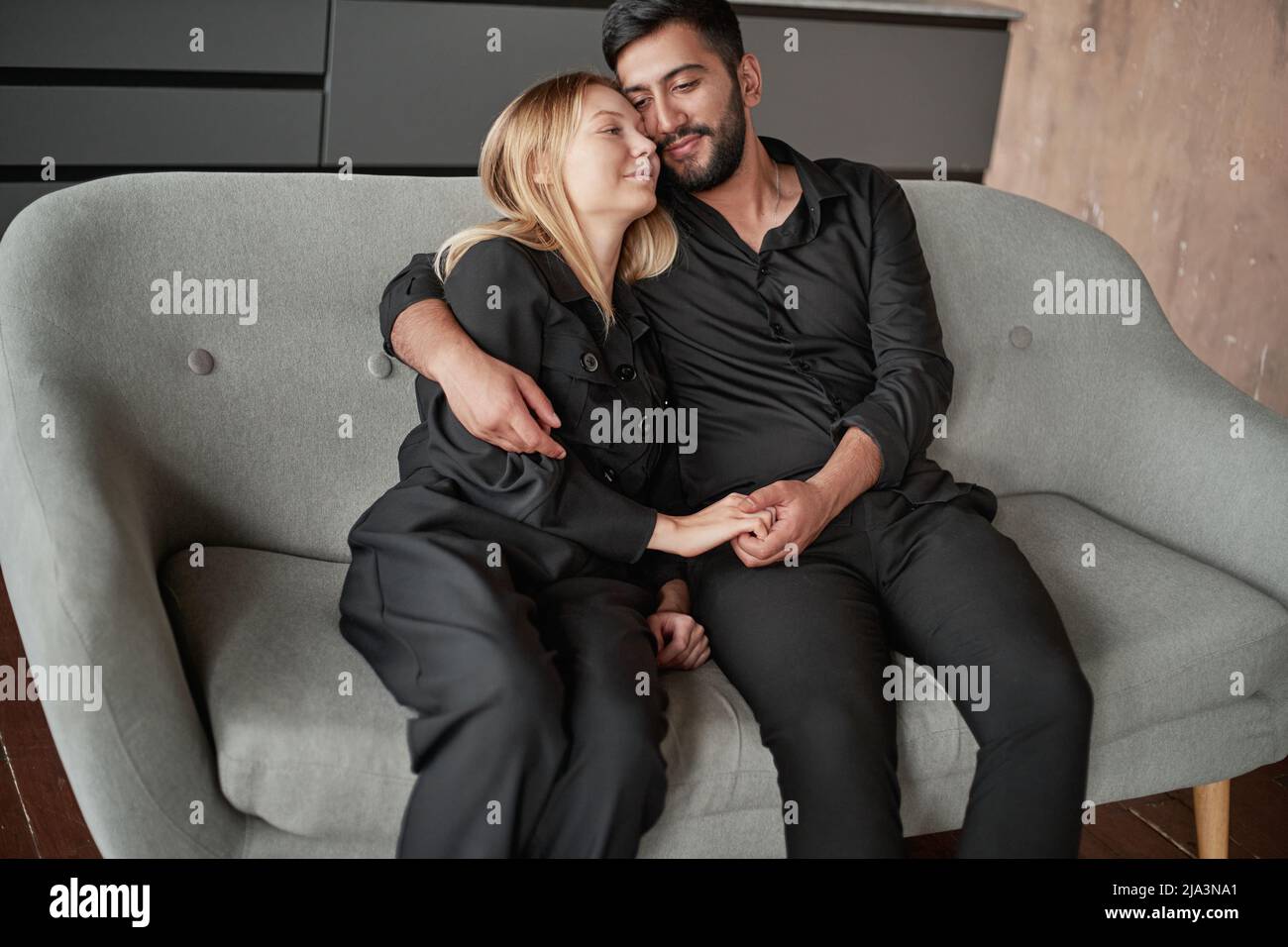 Heureux couple assis sur le canapé. Banque D'Images