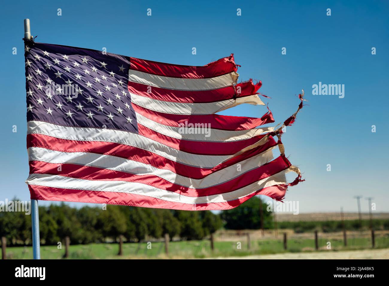 Un drapeau américain en lambeaux flotte dans un champ près de la campagne de Fabens, au Texas, juste à l'est d'El Paso. Banque D'Images