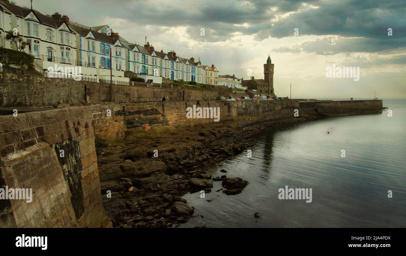 Port de Porthleven, dans les Cornouailles, lors d'une journée de printemps calme, avec vue sur le mur du port et vue sur les bâtiments Banque D'Images