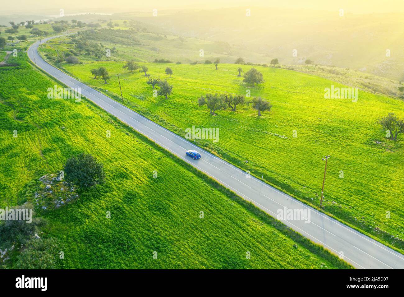 Paysage vert de campagne avec une voiture en descendant une route asphaltée et une voiture, vue de drone d'en haut Banque D'Images