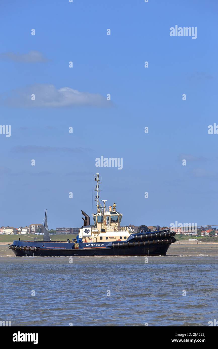 Svitzer Deben aidant le navire à conteneurs OOCL Hong Kong à entrer dans Harwich Haven et le port de Felixstowe. Banque D'Images