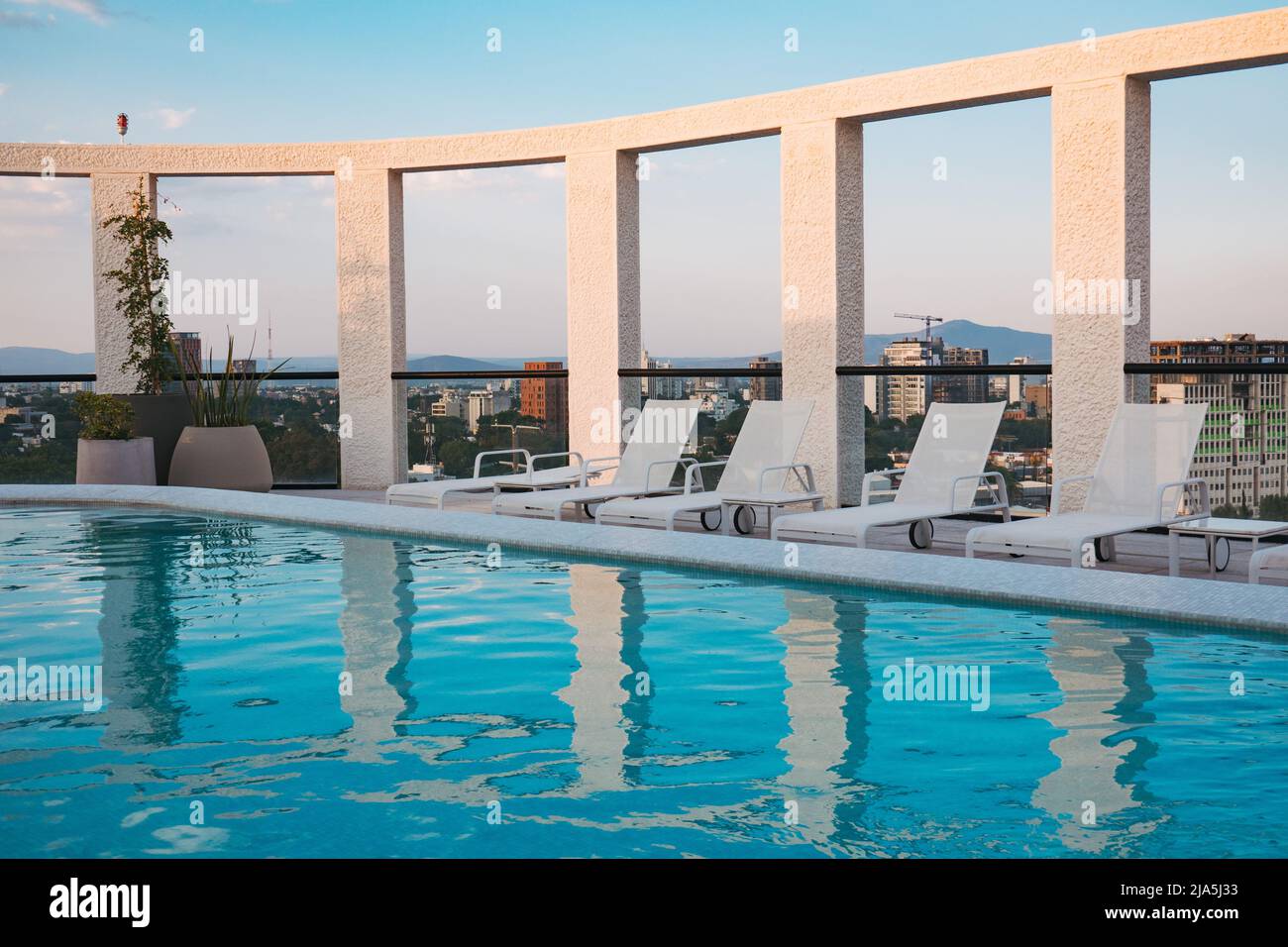 Des baigneurs de soleil bordent une piscine sur le toit sur un appartement moderne dans la ville de Guadalajara, au Mexique Banque D'Images