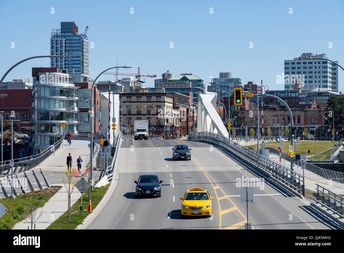 Victoria, C.-B., Canada - 14 avril 2021 : véhicules et piétons franchissez le pont de la rue Johnson nouvellement reconstruit. Banque D'Images