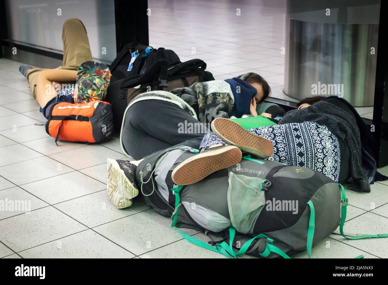 Backpackers dormant à l'étage de l'aéroport Banque D'Images