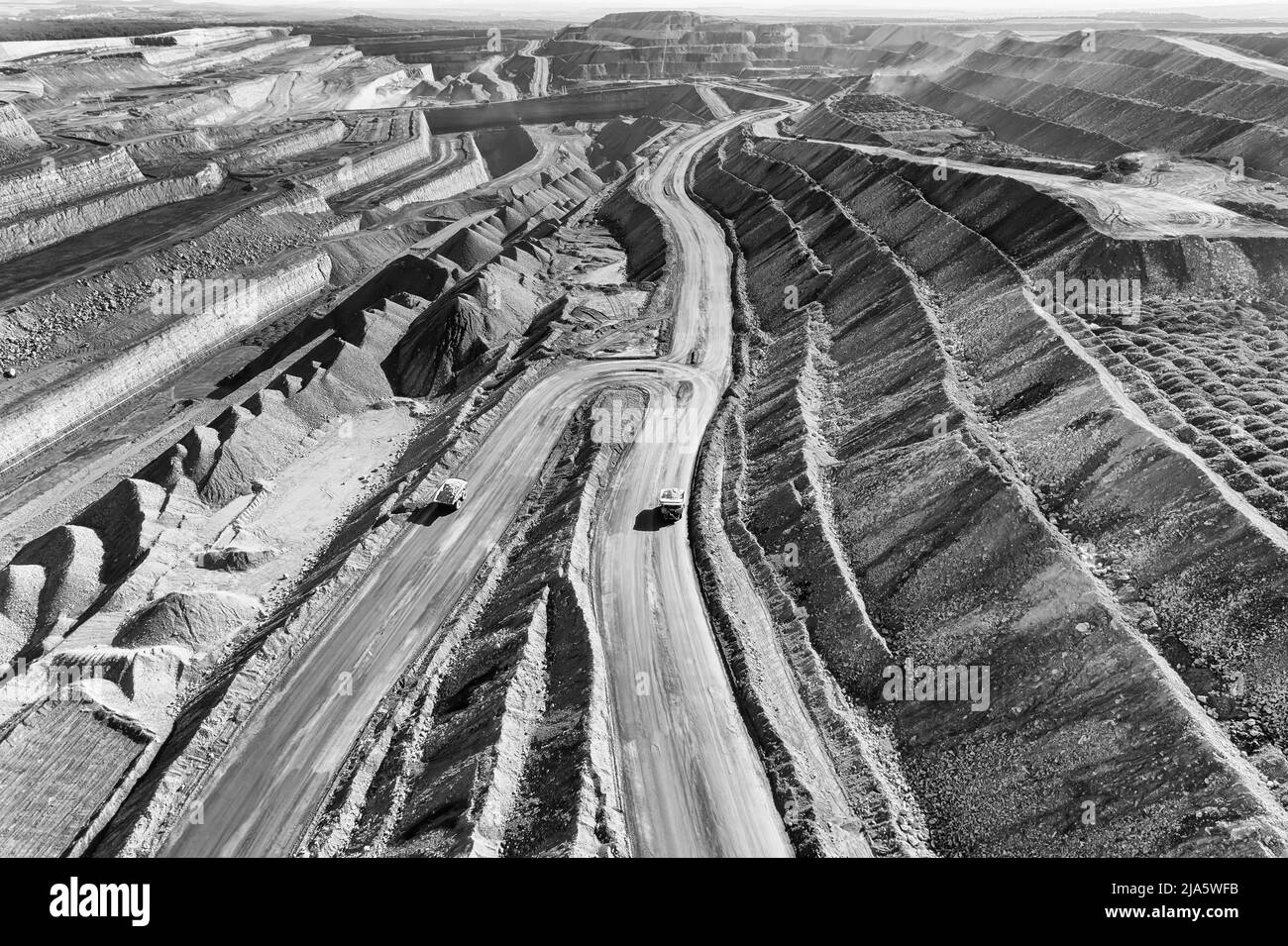 Terrain extrême dépoussiéré de la mine de charbon de fer à ciel ouvert de la vallée Hunter en Australie - vue aérienne sur les camions lourds. Banque D'Images