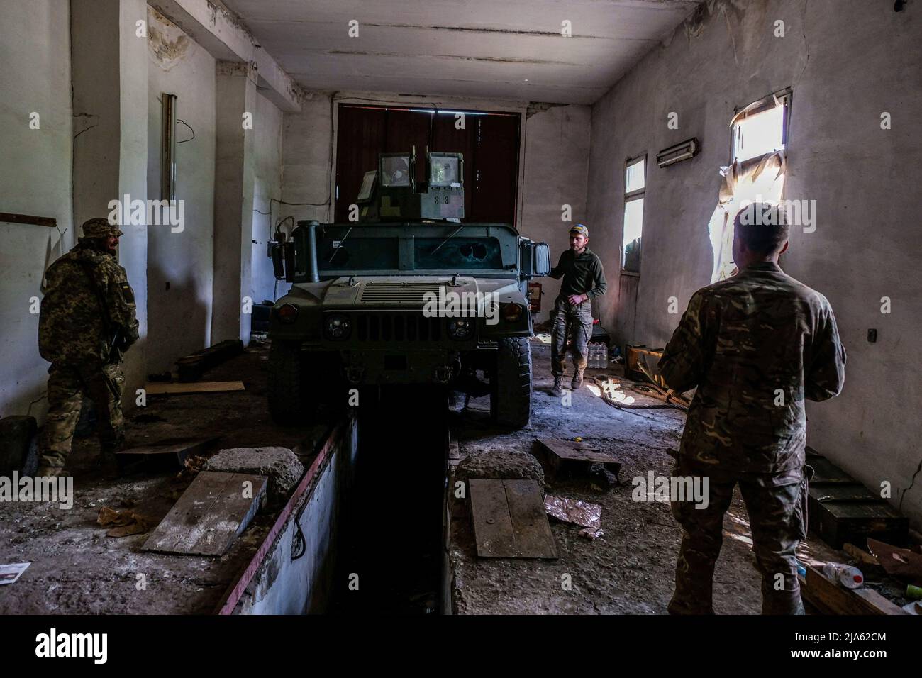 Les soldats se préparent à sortir à l'avant avec un véhicule blindé avec des mitrailleuses montées sur le dessus. Lysychans'k est une ville allongée sur la rive droite de la rivière Donets, dans la région de Luhansk. La ville fait partie d'une zone métropolitaine qui comprend Severodonetsk et Rubizhne; les trois villes constituent l'un des plus grands complexes chimiques d'Ukraine. La ville est maintenant en première ligne depuis que les Russes ont détruit le pont reliant Severodonetsk à Lysychans, les troupes russes attaquent la ville et s'y orientent. La route principale qui relie Lysychansk à Kramatorsk est occupée Banque D'Images