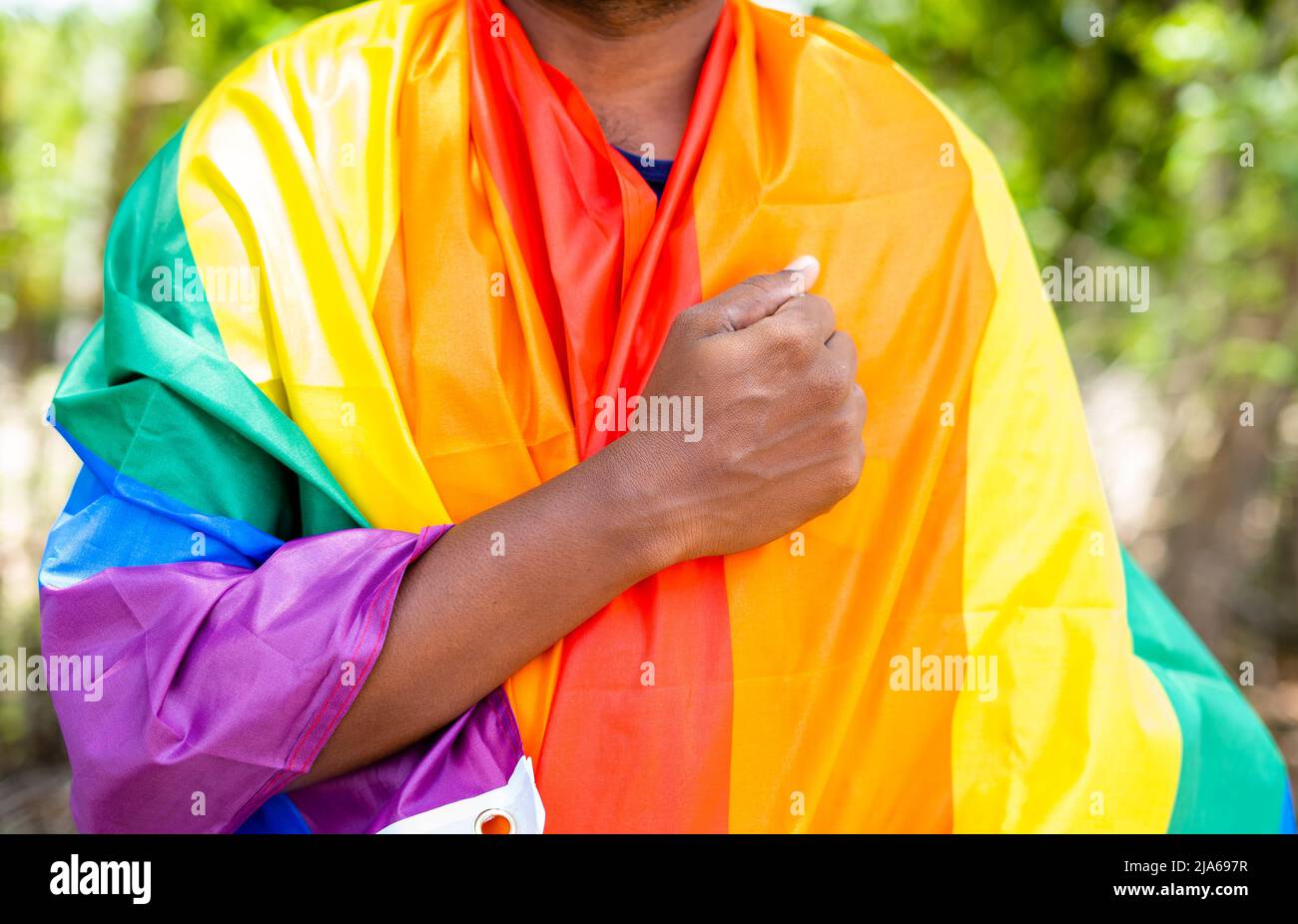 l'homme priant en embrassant le drapeau de fierté lgbtq en embrassant pendant la marche de fierté - concept de liberté et d'individualité. Banque D'Images