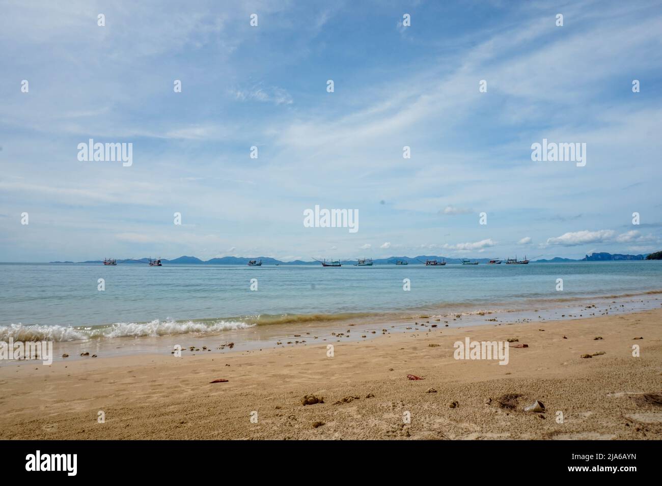 Calm Beach avec des bateaux de pêche à l'horizon, Thaïlande, région de Krabi Banque D'Images