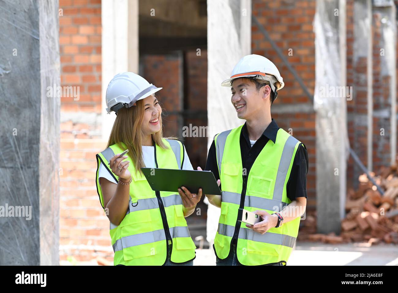 Équipe de spécialistes discutant des détails de planification et de développement tout en faisant une promenade dans le chantier de construction Banque D'Images