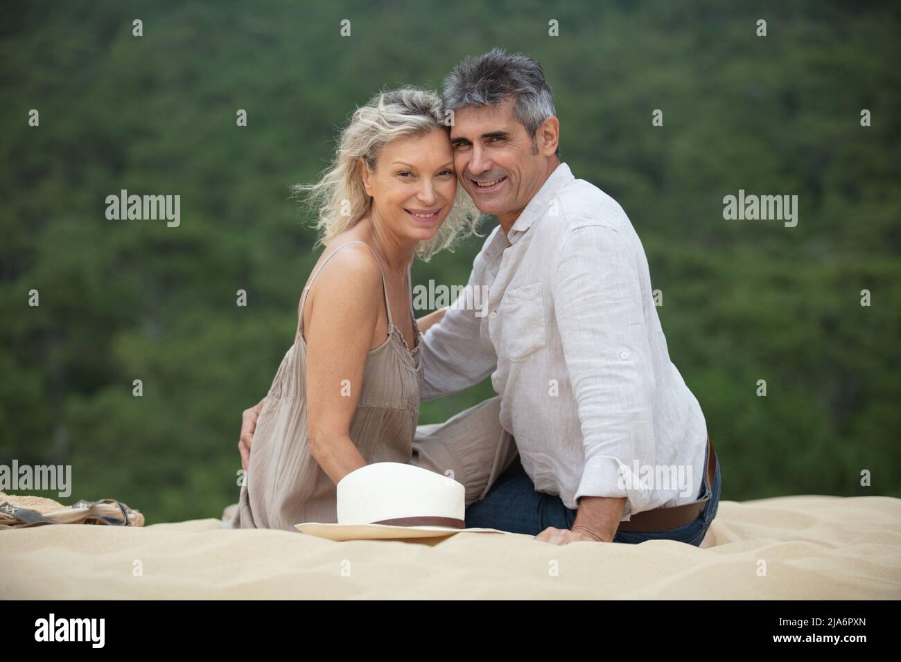 couple senior élégant se détendant dans les dunes de sable Banque D'Images