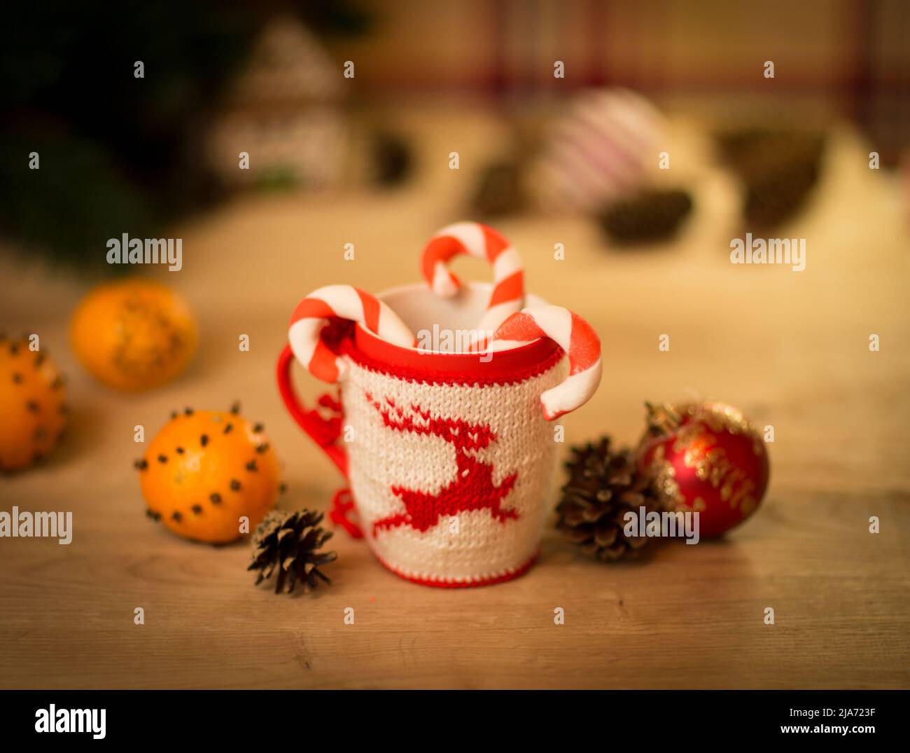 L'abri de la laine en tissu brodé avec mug sur la table en bois de cerf avec mug mandarines et un bonbon Banque D'Images