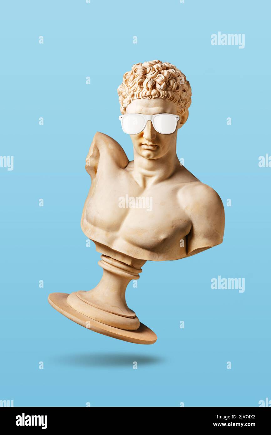Concept créatif avec ancienne statue en lunettes de soleil sur fond bleu clair. Concept de fête minimal. Banque D'Images