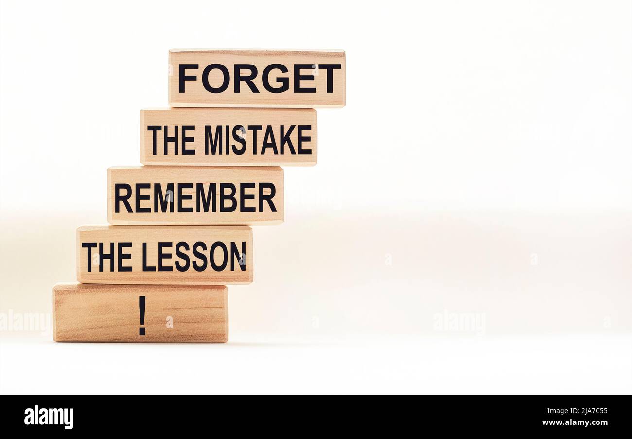 Citation motivante et inspirante - oubliez l'erreur, rappelez-vous la leçon écrite sur des blocs de bois sur un fond blanc Banque D'Images