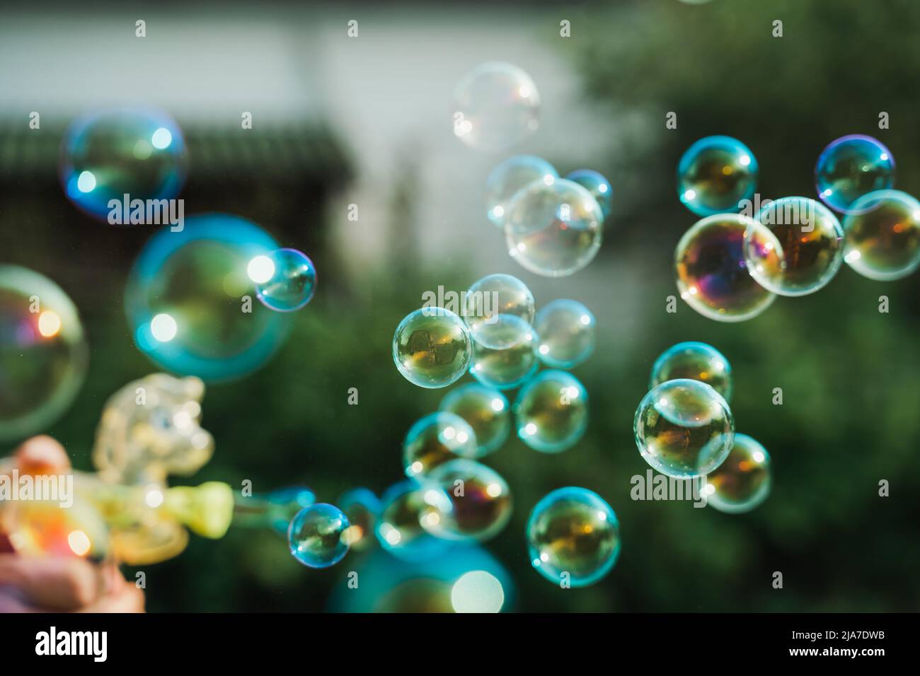 Pistolet à bulles de savon poney, souffleur. Fête pour les enfants. Filles, chidren jouant drôle de jeu de famille avec papa, père. Activités de plein air en été dans le vert p Banque D'Images