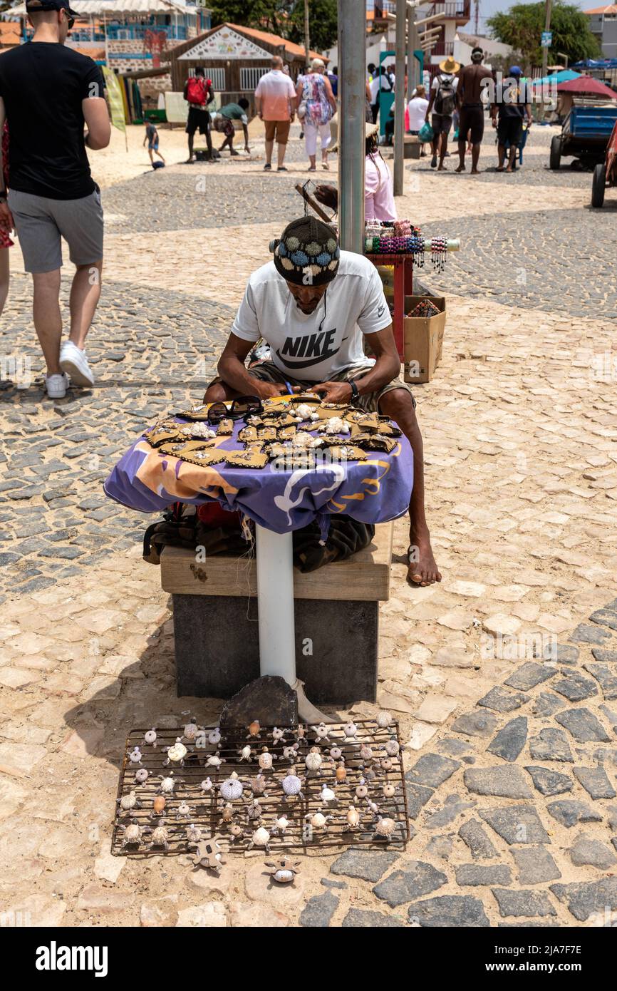 Cap-Vert Sal homme local faisant des ornements de coquillages et porte-monnaie pour les touristes comme souvenirs de gagner une vie, Santa Maria, Cabo Verde, Afrique Banque D'Images