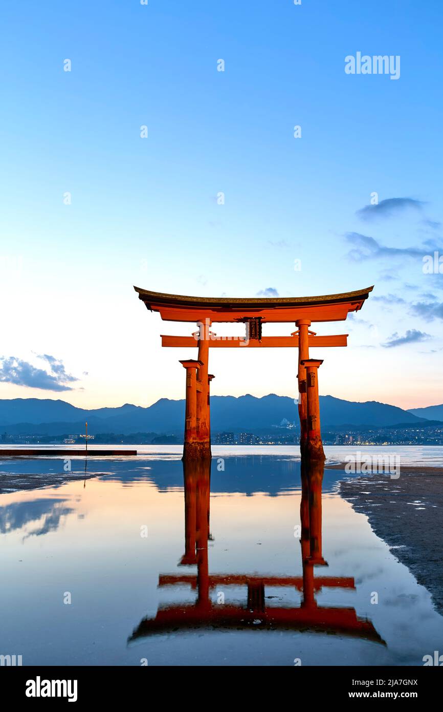 Japon. Miyajima. Hiroshima. Sanctuaire d'Itsukushima et porte de torii flottante au coucher du soleil Banque D'Images