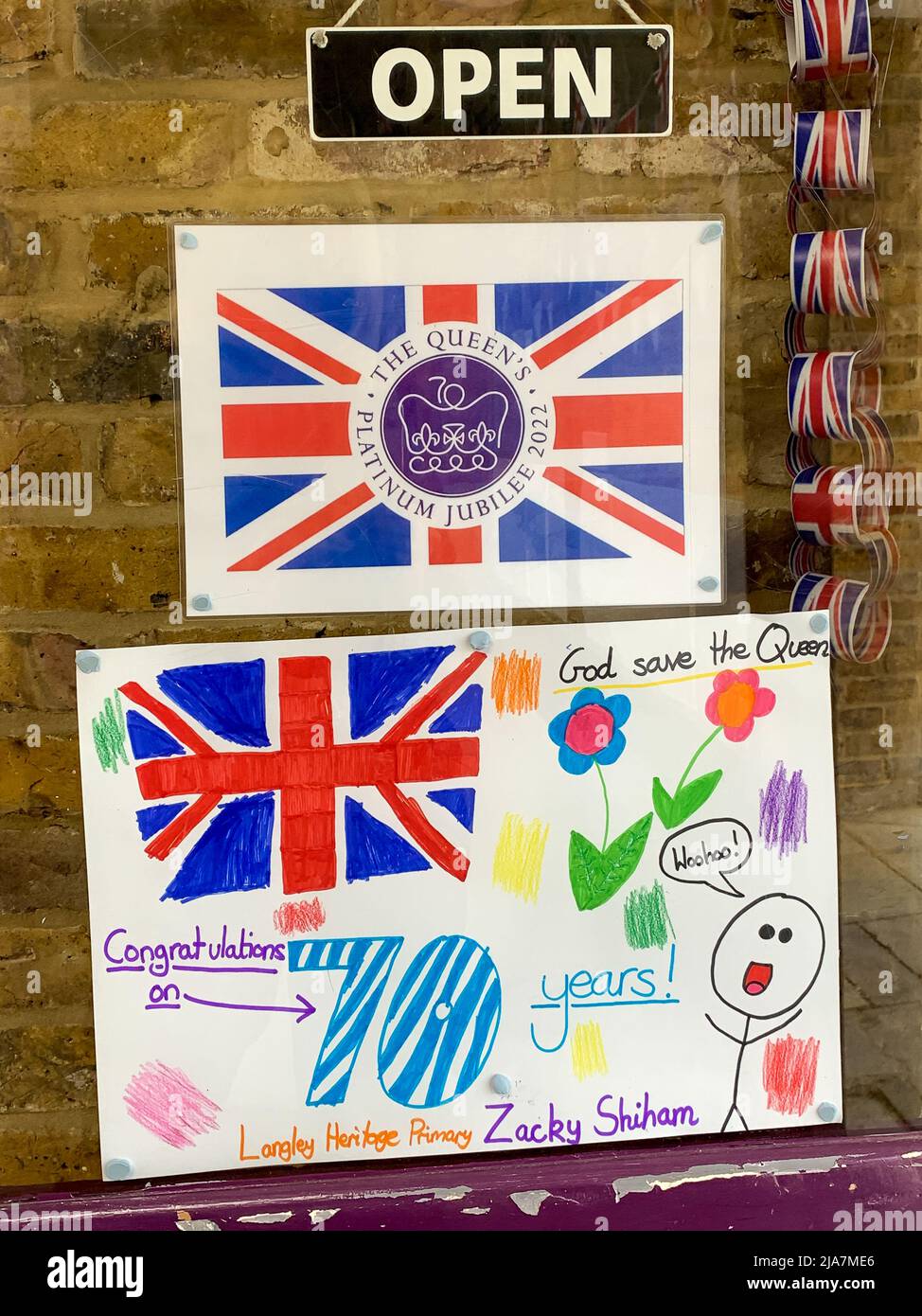 Datchet, Berkshire, Royaume-Uni. 25th mai 2022. La billetterie de la gare de Datchet est très colorée avec de belles peintures et dessins du Jubilé de platine dans les fenêtres. Les navetteurs apprécient vivement de voir les œuvres d'art réalisées par les enfants des écoles locales de l'école primaire Langley Heritage en prévision des célébrations du week-end prochain. Crédit : Maureen McLean/Alay Banque D'Images