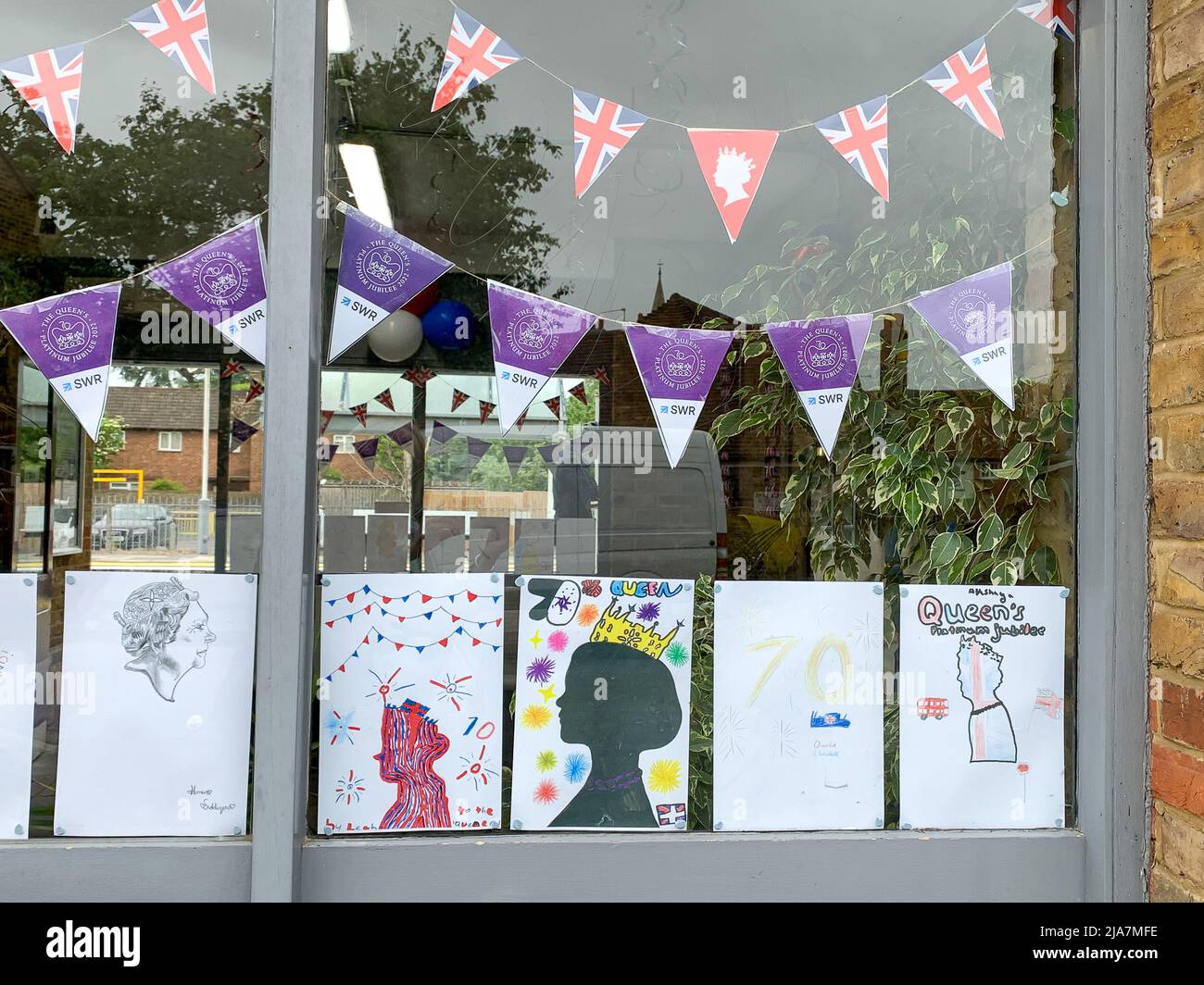 Datchet, Berkshire, Royaume-Uni. 25th mai 2022. La billetterie de la gare de Datchet est très colorée avec de belles peintures et dessins du Jubilé de platine dans les fenêtres. Les navetteurs apprécient vivement de voir les œuvres d'art réalisées par les enfants des écoles locales de l'école primaire Langley Heritage en prévision des célébrations du week-end prochain. Crédit : Maureen McLean/Alay Banque D'Images