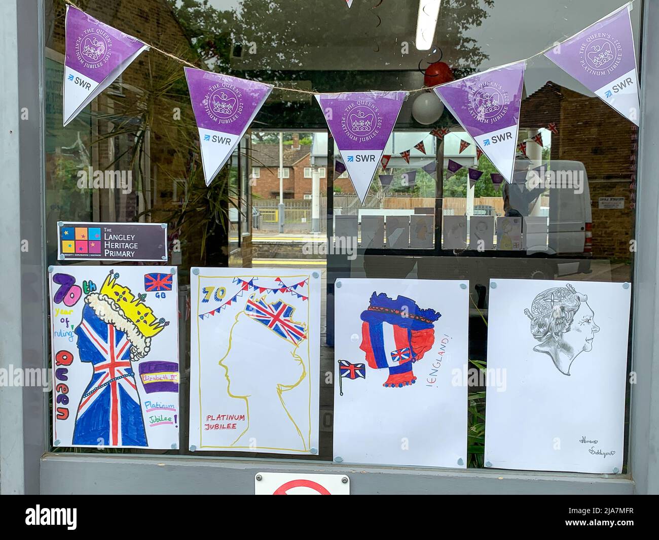 Datchet, Berkshire, Royaume-Uni. 25th mai 2022. La billetterie de la gare de Datchet est très colorée avec de belles peintures et dessins du Jubilé de platine dans les fenêtres. Les navetteurs apprécient vivement de voir les œuvres d'art réalisées par les enfants des écoles locales de l'école primaire Langley Heritage en prévision des célébrations du week-end prochain. Crédit : Maureen McLean/Alay Banque D'Images