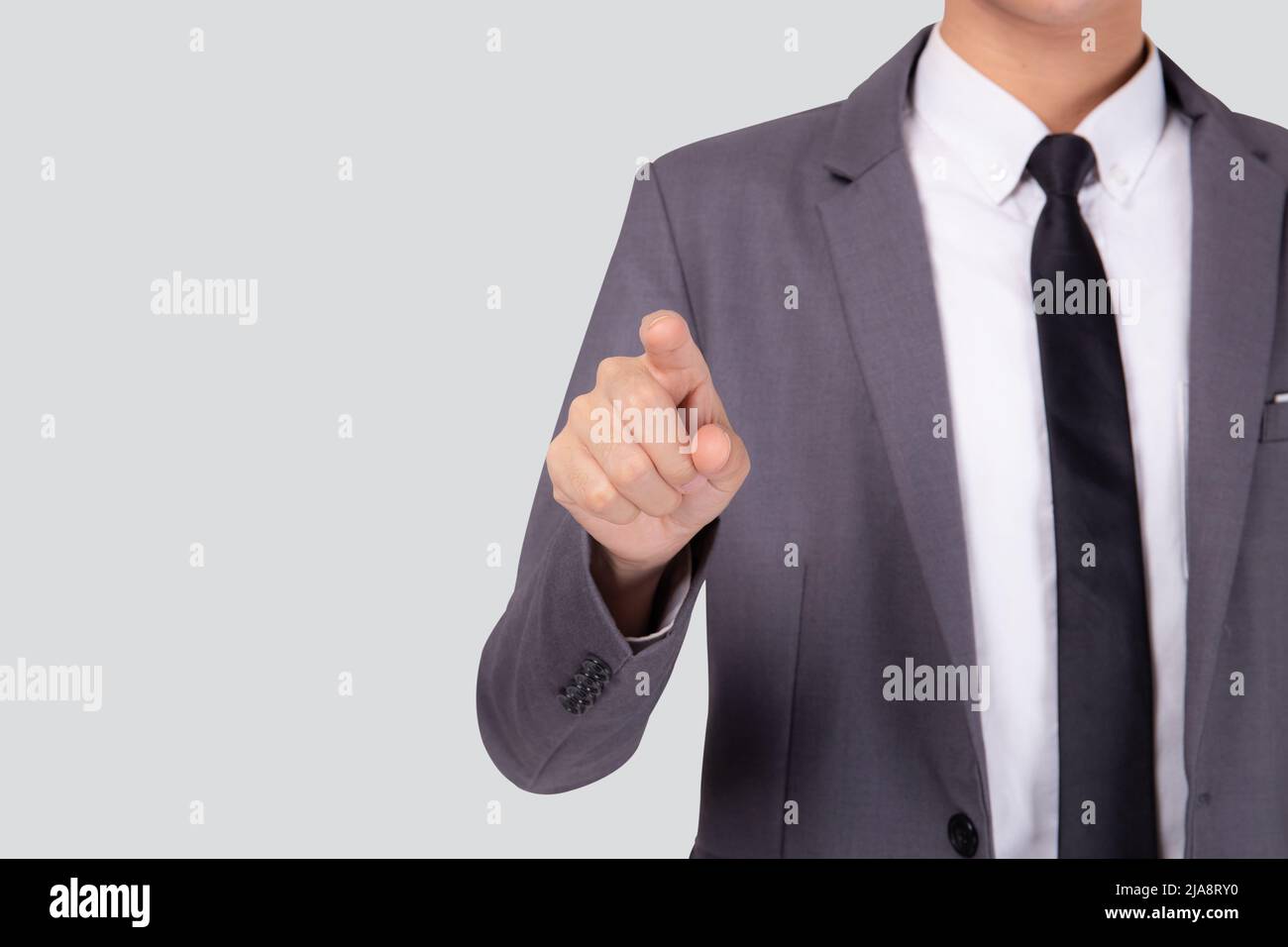 Jeune homme d'affaires pointant avec le doigt pour la publicité isolée sur fond blanc, homme geste toucher ou pousser pour montrer la présentation, interface pour Banque D'Images