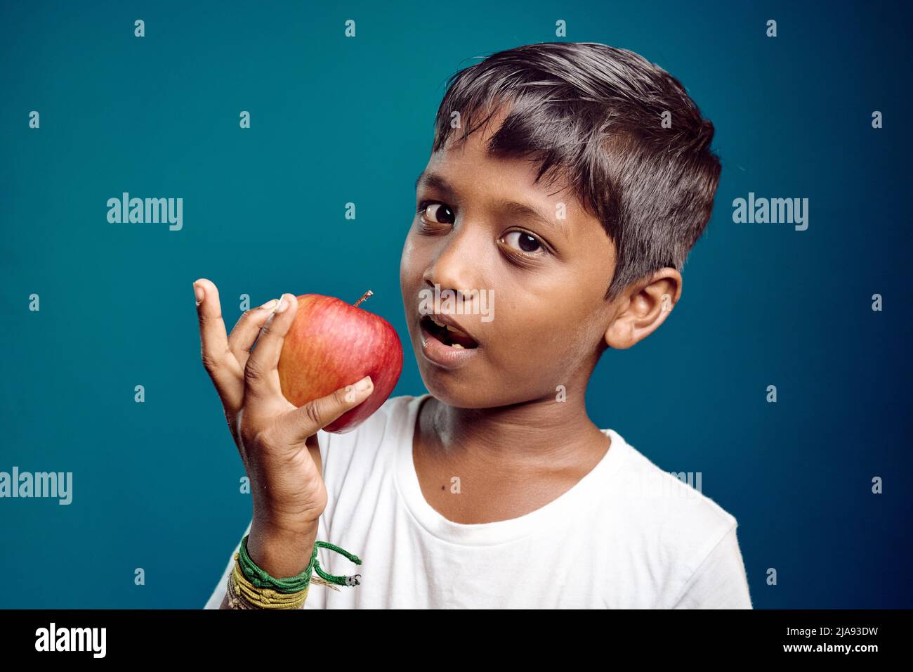 Garçon asiatique de 8-10 ans posant avec la pomme. Santé Banque D'Images