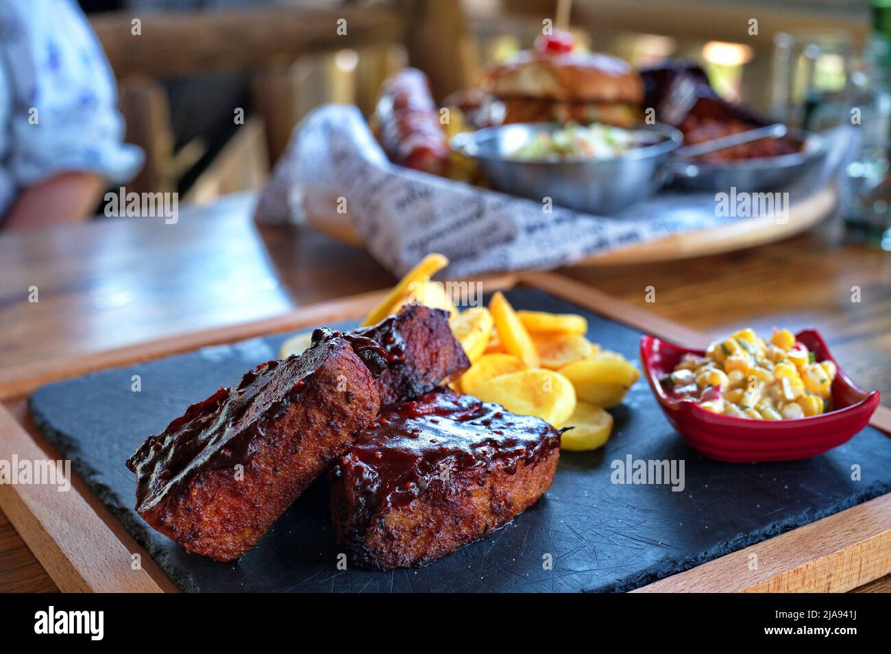 Côtes avec pommes de terre frites et salade sur table rustique Banque D'Images