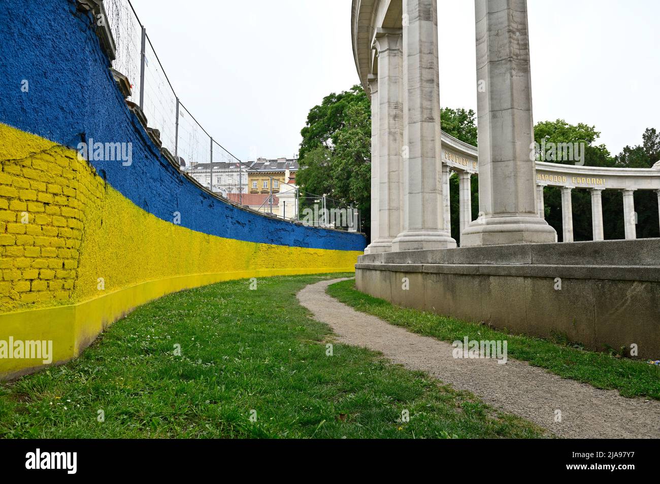 Vienne, Autriche. Monument des héros sur Schwarzenbergplatz avec le 'mur de brique' en arrière-plan dans les couleurs nationales ukrainiennes de bleu et de jaune Banque D'Images