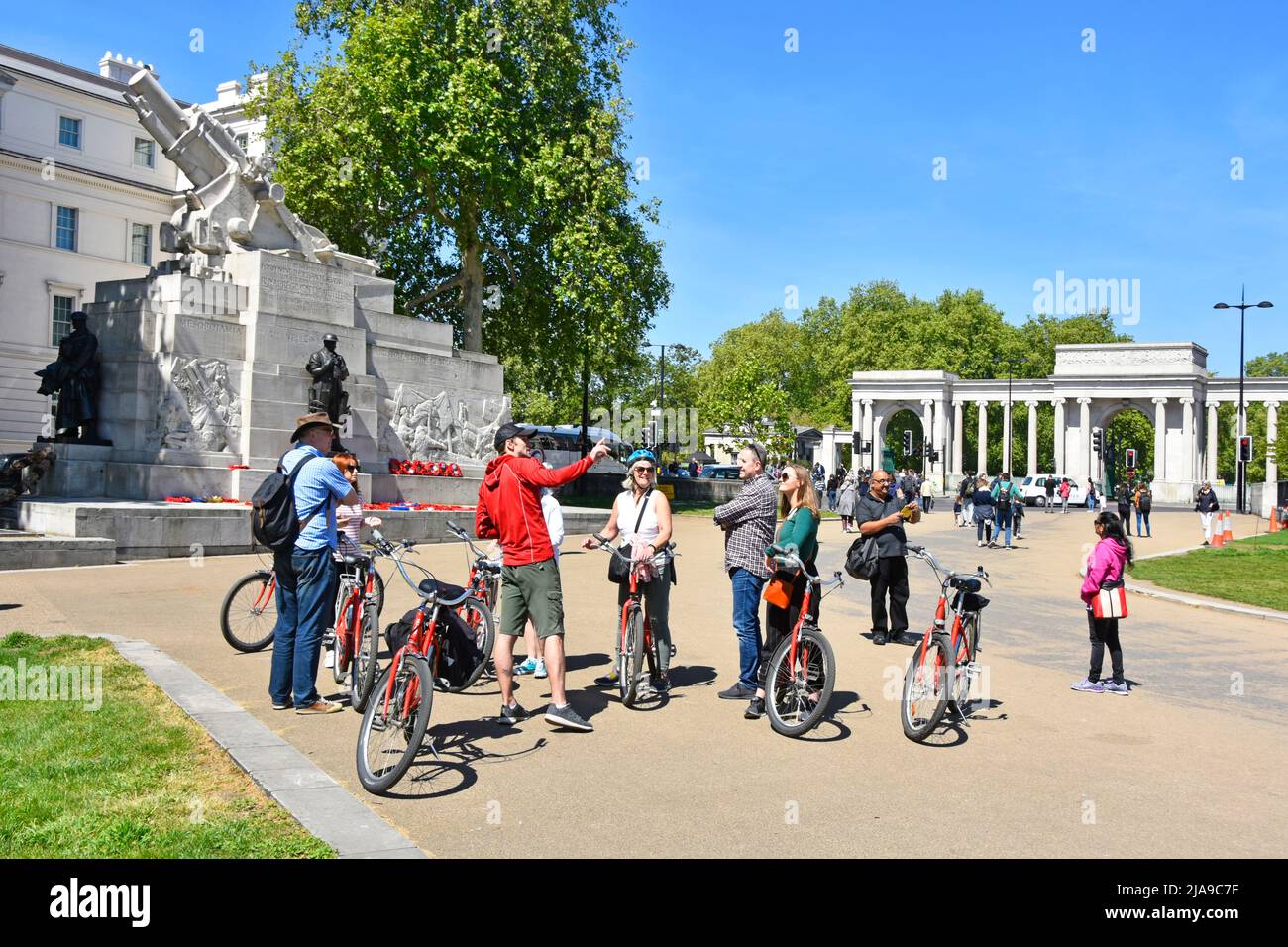 Guide touristique pointant visite guidée pour un groupe d'hommes et de femmes touristes sur des vélos loués lors d'une visite à Hyde Park Corner Londres Angleterre Royaume-Uni Banque D'Images