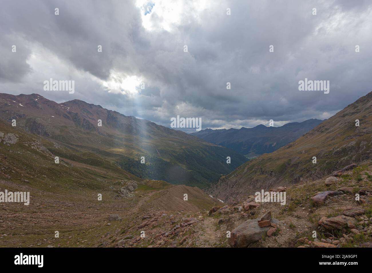 Lumière du soleil éclatante qui brille à travers le trou des nuages jusqu'à la scène de la chaîne de montagnes alpines Banque D'Images