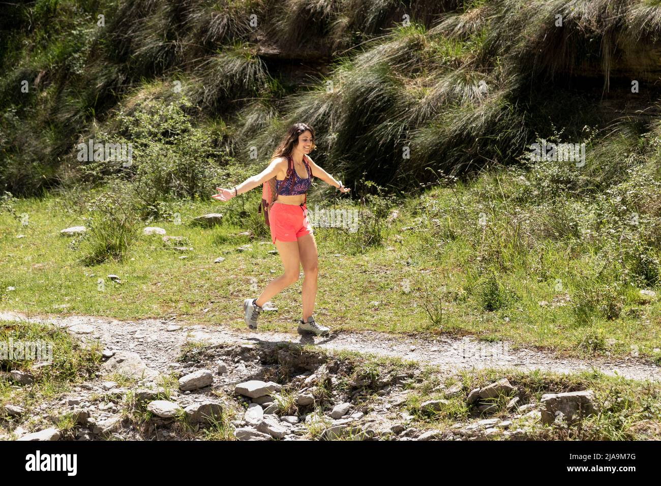 brunette femme courir avec joie sur un sentier de montagne Banque D'Images