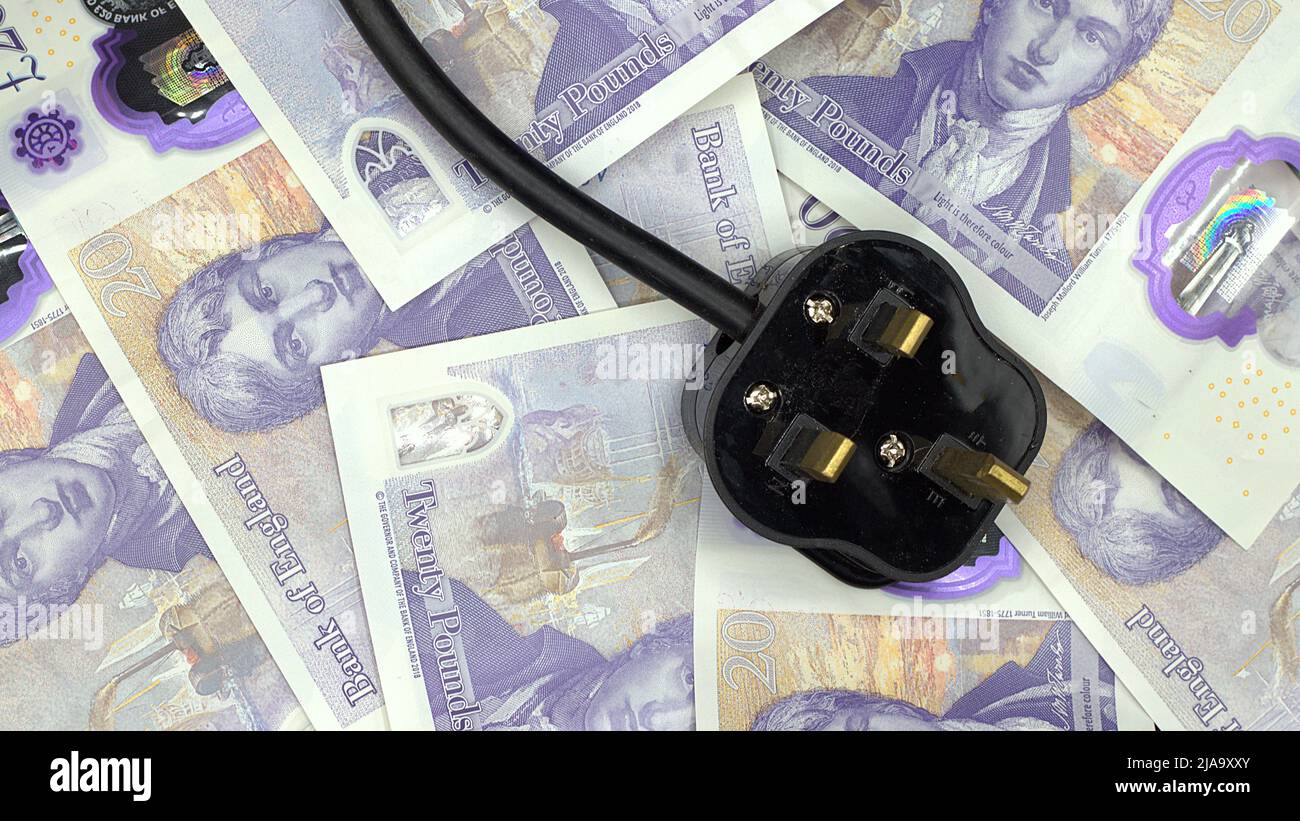 Le coût croissant de l'électricité représenté par une fiche britannique de 3 broches sur un peu d'argent Banque D'Images