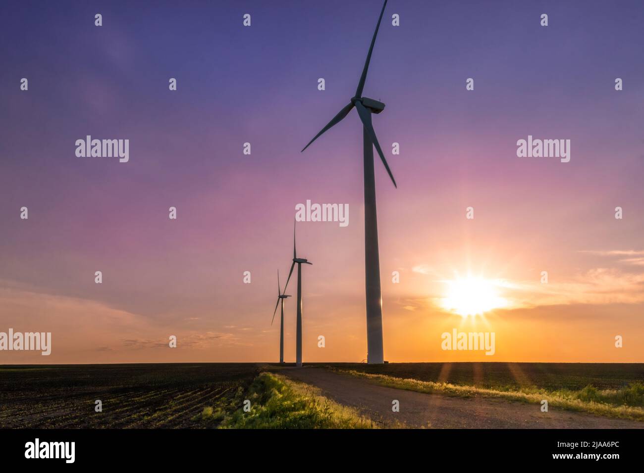 Trois moulins à vent se tenant dans un champ du centre-ouest pendant le coucher du soleil. Banque D'Images