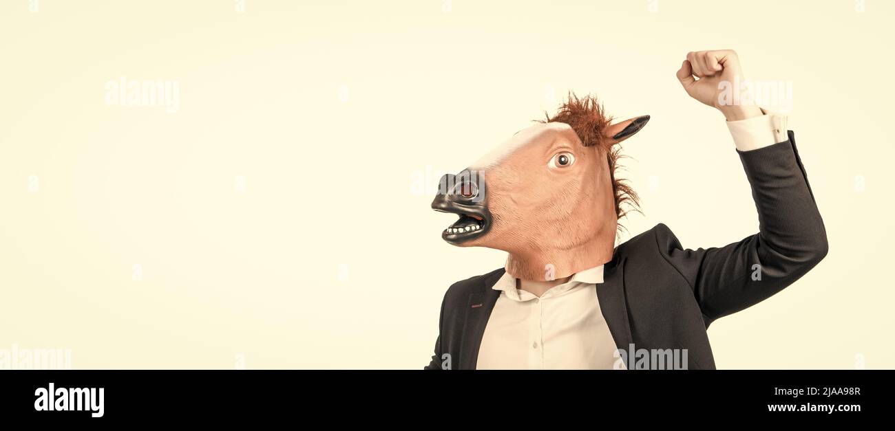 Homme d'affaires dans le masque de tête de cheval avec le geste de force de poing levé, cheval de travail Banque D'Images