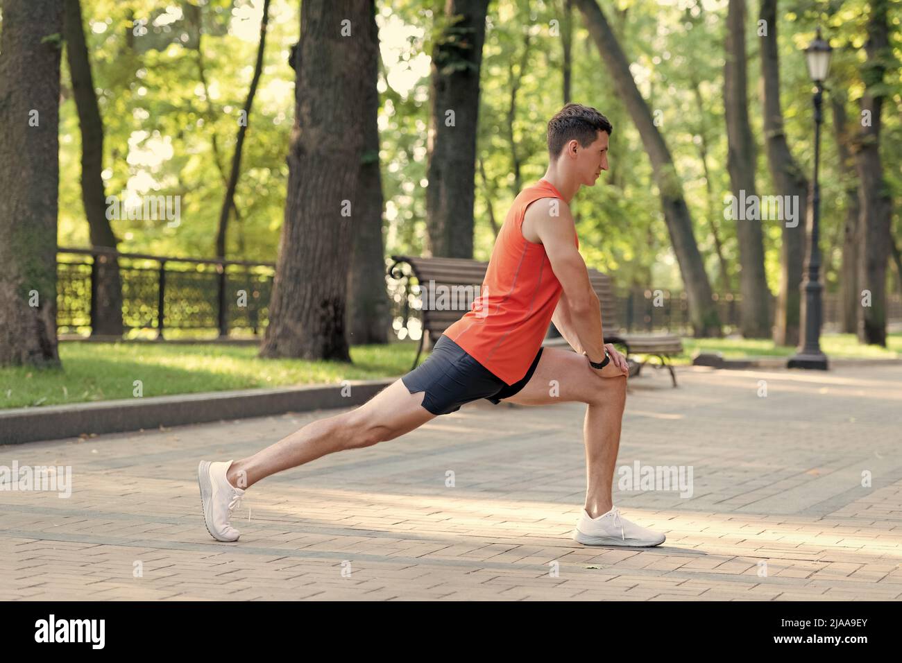 Homme sportif en position de fente. Étirez la jambe après l'entraînement. Routine d'étirement Banque D'Images