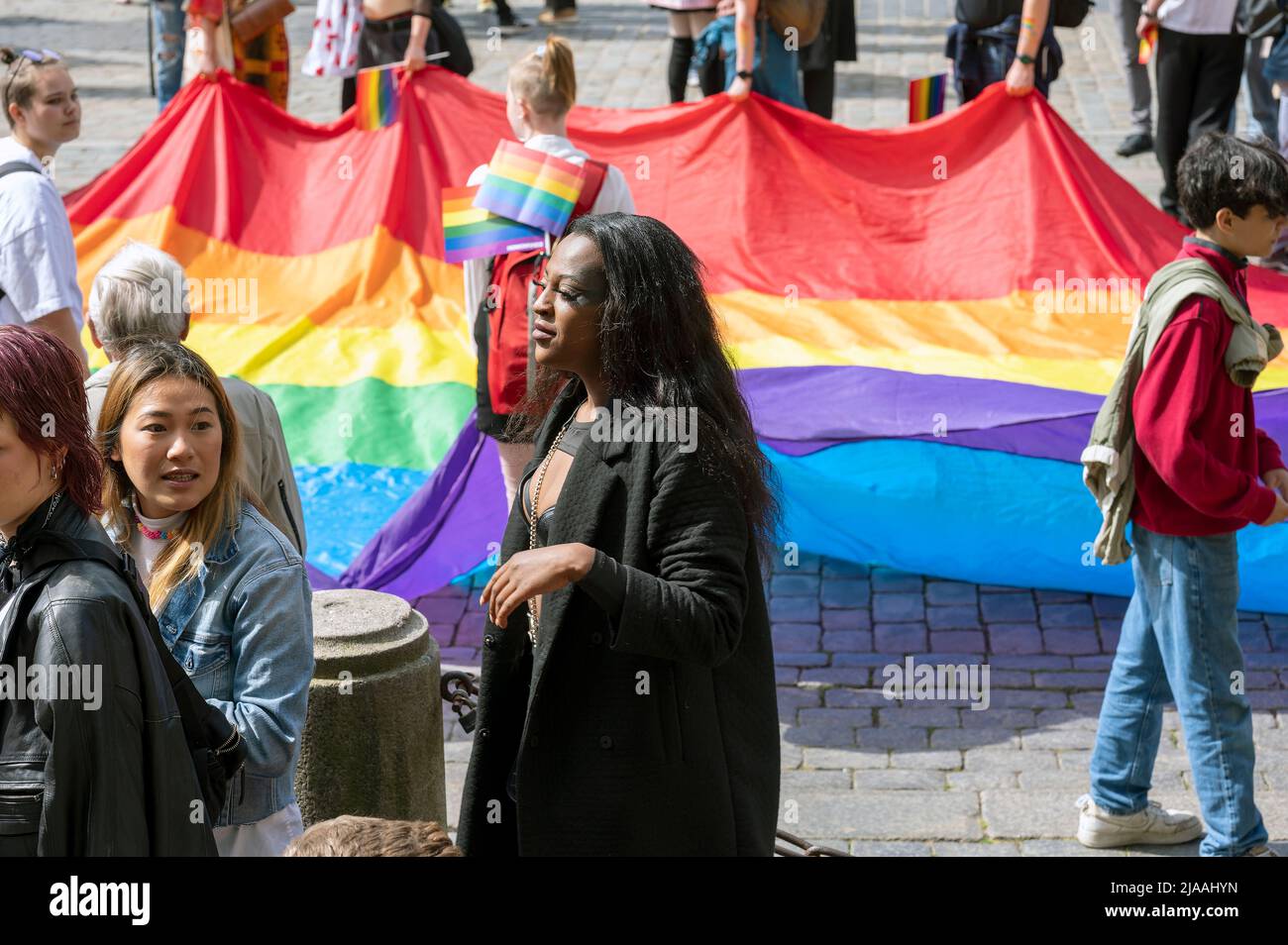 Parade de fierté d'Aarhus - femme noire et asiatique de l'est avec un grand drapeau arc-en-ciel LGBT en arrière-plan - Aarhus, Danemark, le 28 mai 2022 Banque D'Images