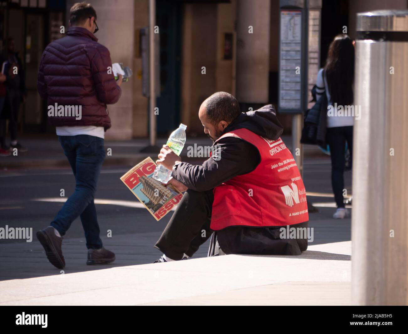 Un vendeur de gros problèmes qui fait une pause-eau à Liverpool Street à Londres Banque D'Images