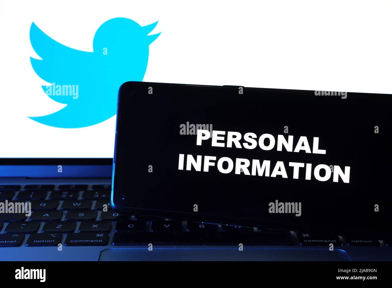 Mots INFORMATIONS PERSONNELLES visibles sur smartphone et logo Twitter sur ordinateur portable flou derrière. Concept. Stafford, Royaume-Uni, 29 mai 2022 Banque D'Images