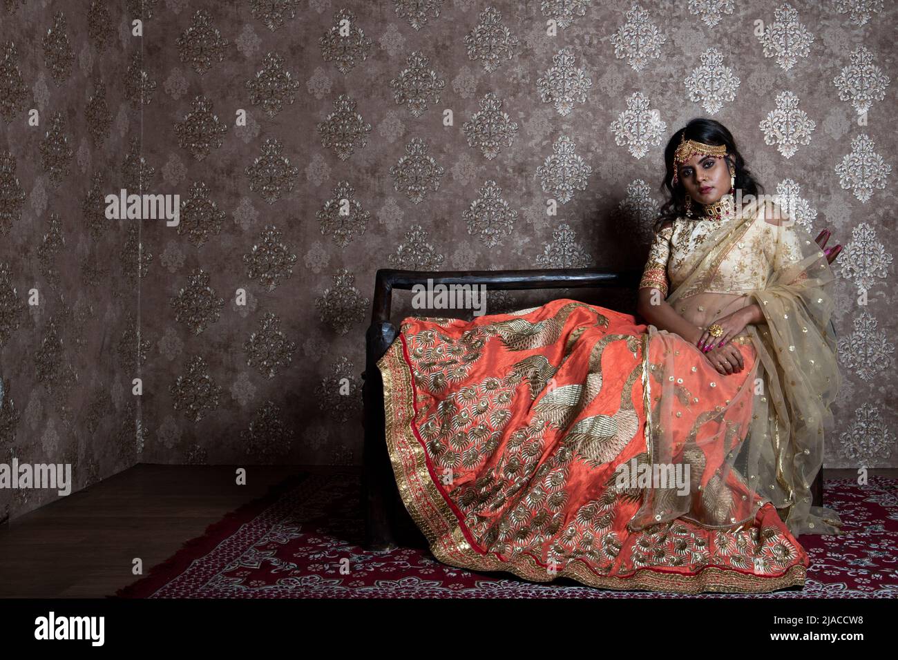 Mannequin indienne portant un lehemga orange et beige et des bijoux représentant un look ethnique indien Banque D'Images
