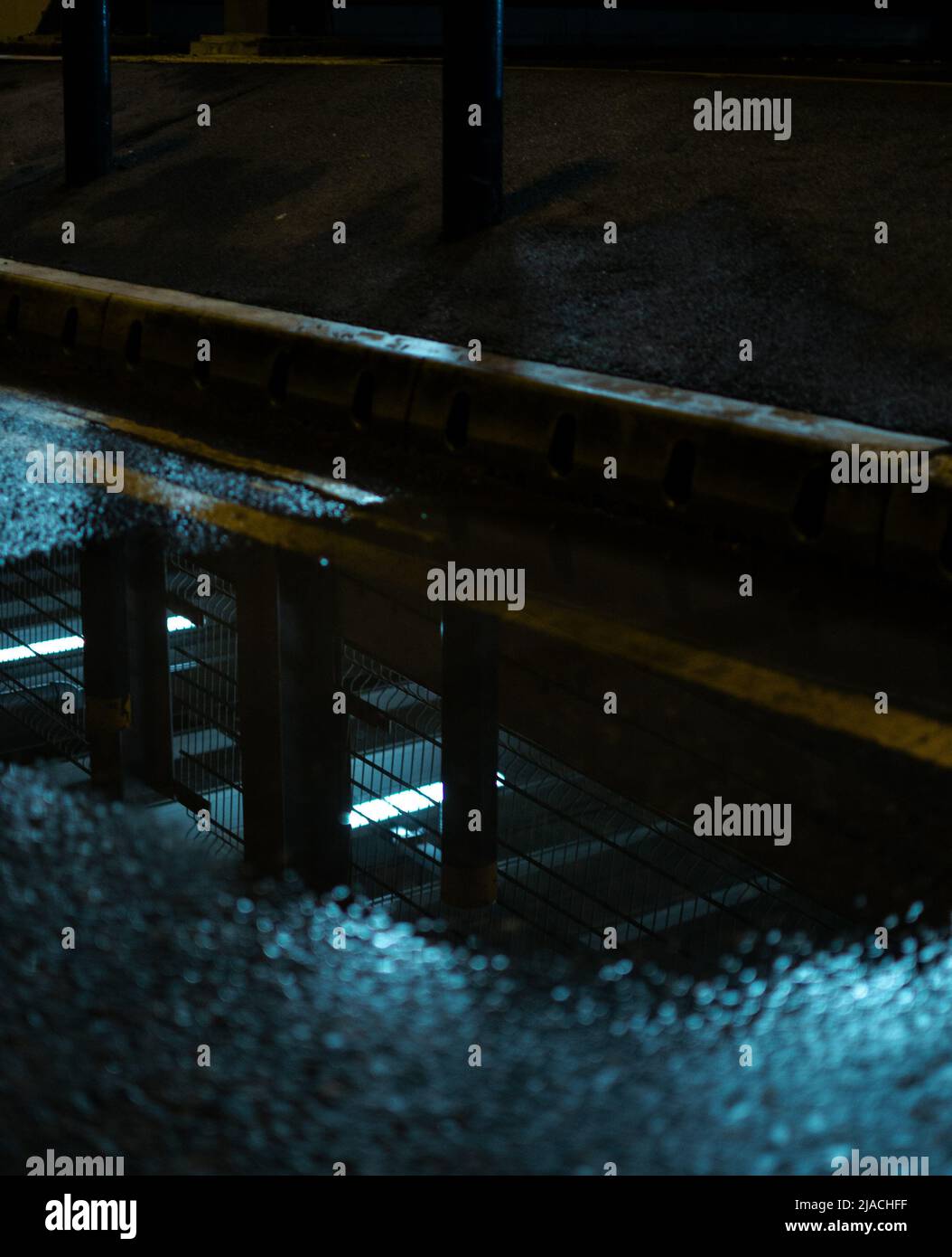 Reflet d'un parking de plusieurs étages dans une flaque, situé à l'aéroport international de Manchester, Greater Manchester, Royaume-Uni. Banque D'Images
