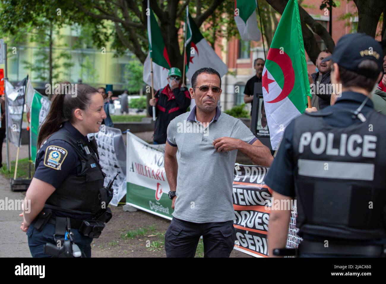 La police de Montréal (SPVM) est en état d'alerte pendant toute la manifestation. Les manifestants ont dit que c'était leur façon des intimider. Quatre ans après son entrée dans la diaspora algérienne, le mouvement Hirak continue de lutter pour la démocratie à Montréal. Organisé par tous nos Unis pour notre Algerie, des centaines de manifestants se sont rassemblés devant le Consulat algérien pour demander la destitution des dirigeants politiques actuels, dirigés par le président Abdelmadjid Tebboune. Invoquant la corruption chronique et l'absence de résolutions prévoyables, les manifestants ont qualifié le gouvernement de gouvernement mafieux. Banque D'Images