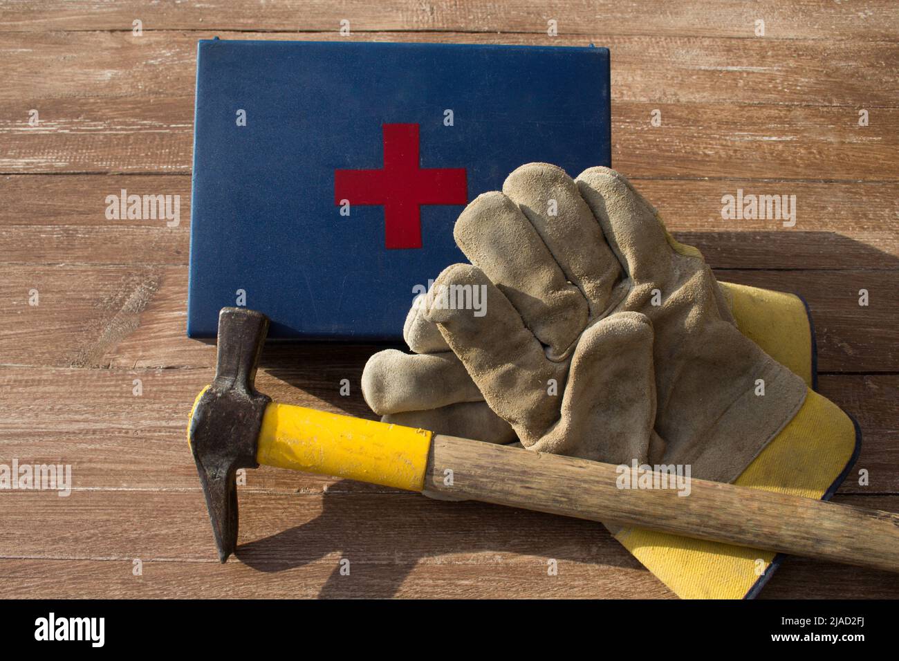 Image d'une paire de gants de travail, d'un marteau de maçon et d'une trousse de premiers soins. Référence aux accidents du travail Banque D'Images