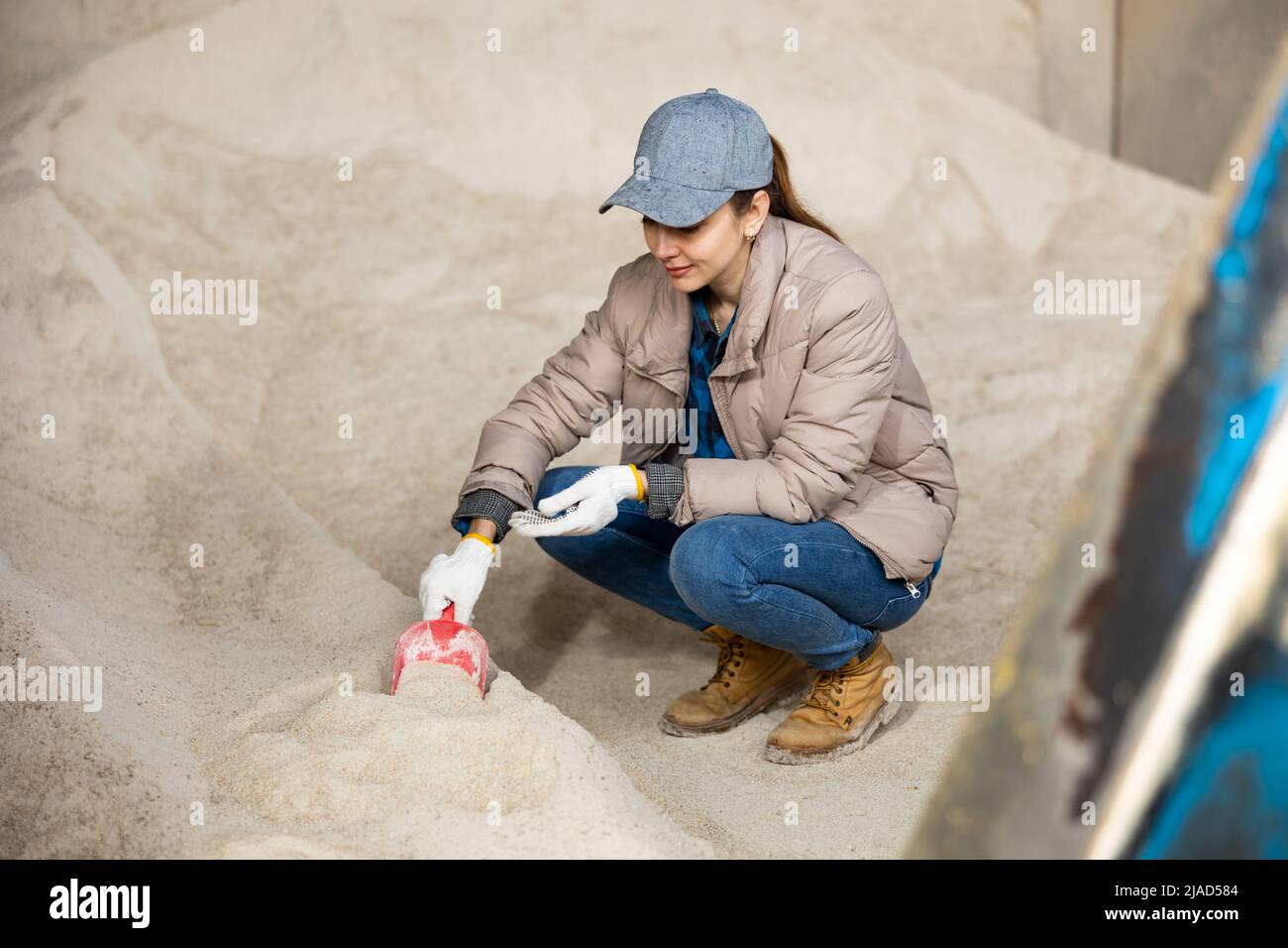 Une femme paysanne s'écrase au tas de farine de maïs Banque D'Images