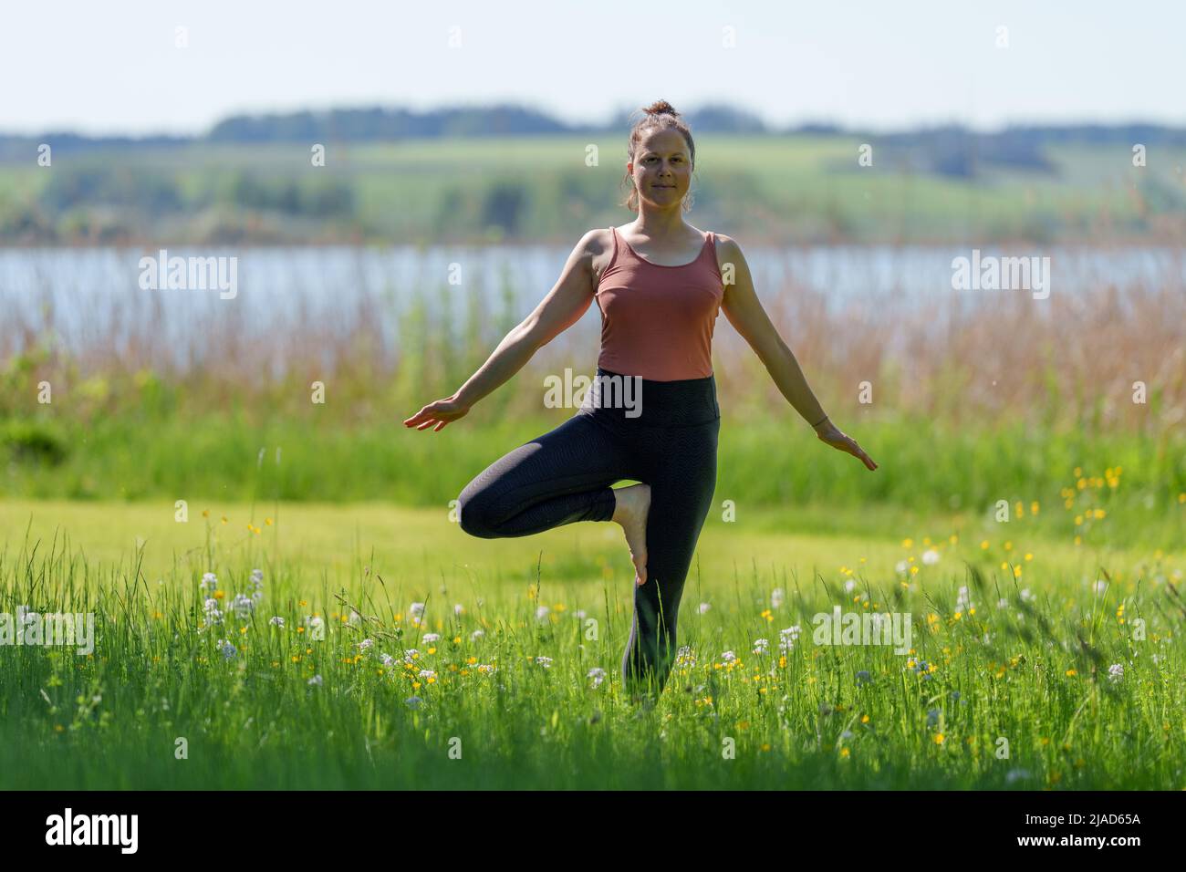 Femme faisant la pose d'arbre par Wallersee, Salzbourg, Autriche Banque D'Images